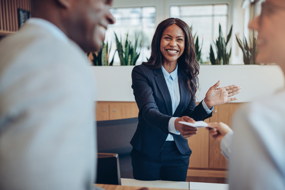 Friendly,Young,African,American,Concierge,Standing,Behind,A,Reception,Counter